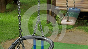 Empty children`s swings on a chain swinging