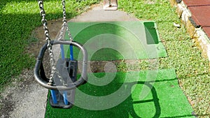 Empty children`s swings on a chain swinging