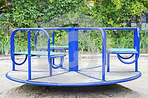 Empty childrens metal carousel on outdoor playground. Concept of entertaining street leisure for children, improvement of the