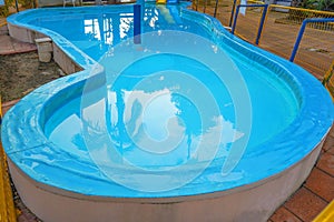 Empty childrens pool. Children`s swimming pool with sunny reflections