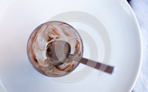 Empty chocolate glass on white plate in a restaurant