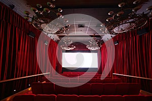 Empty cinema hall with large chandeliers and seats