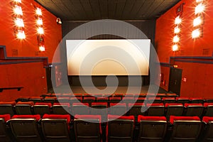 Empty cinema hall. Red seats on the background of a white movie screen