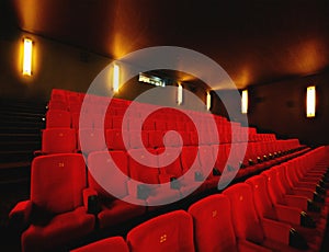 Empty cinema or movie theatre with row of red seats at night before a movie or film theater interior room. Chair in a