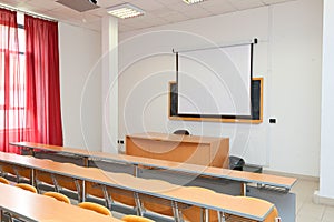 Empty classroom with chairs, desks and chalkboard