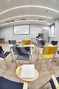 Empty classroom with Ñhairs and notepads