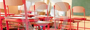 Empty classroom with school desks, chairs and blackboard. Education concept.