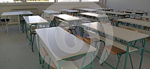 Empty classroom with wooden desks, chalk board and big windows in school. New light tables in the classroom. New school