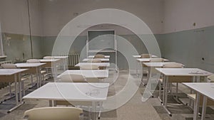 Empty classroom with wooden desks, white and green chalk boards in school. empty classroom. Abandoned School classroom