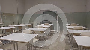 Empty classroom with wooden desks, white and green chalk boards in school. empty classroom. Abandoned School classroom