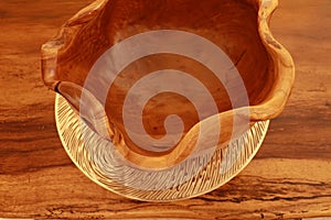 Empty clay bowls on a wooden table. Top view. Close up of a carved wooden bowl. Decorative wooden bowl, artwork