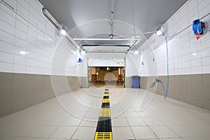 Empty clean car wash room with drainage device and photo