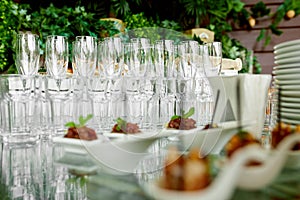 Empty, clean, crystal champagne glasses and crystal glasses for water stand on a serving table