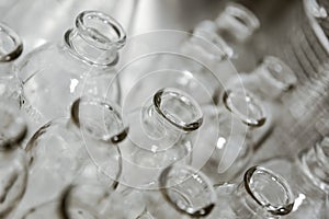 Empty clear glass medicine bottles. Medical manufacturing background