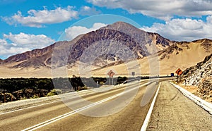 Empty coastal asphalt highway road in barren desert landscape - Panamericana, North Chile, Atacama Region