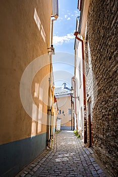 Empty cobbled alley amidst residential buildings in old town at city against sky