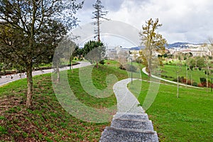 Empty cobblestone path, track, trail or pathway through the trees and green grass lawn