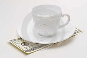 Empty coffee cup and 100 USD