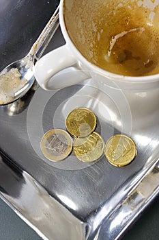 Empty coffee cup with euro coins