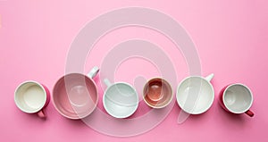 Empty coffee cups white and pink color against pink background, top view