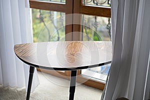 an empty coffee table made of wood next to the window, indoor shot