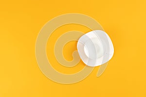 Empty coffee or tea cup isolated on yellow. Top view. Copy space