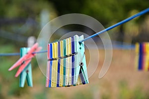 Empty colorful clothes pegs on string in garden