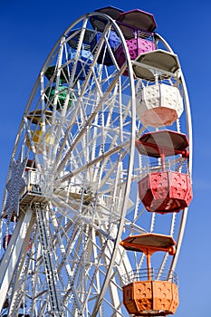 An empty colorful Ferris wheel stands still in the sun