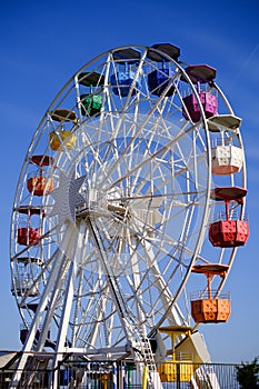 An empty colorful Ferris wheel stands still in the sun