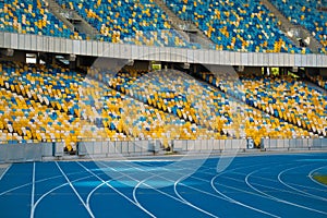 Empty colorful stadium seats and running tracks.