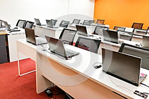 Empty computer classroom with monitors on top of table