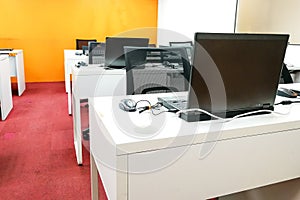 Empty computer classroom with monitors on top of table