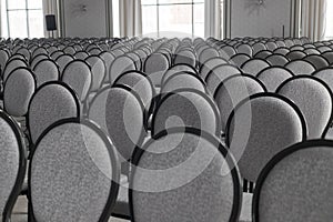 Empty conference hall. Empty rows of grey chairs. Monochrome