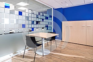 Empty conversation room with table and chairs in modern office interior.