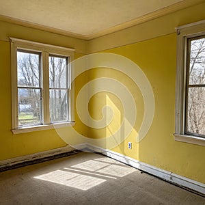 Empty corner yellow room with light from window