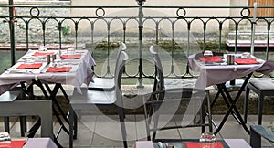 Empty cosy french street cafe or brasserie located on small rive photo