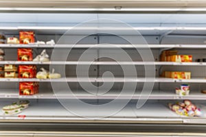 Empty counters with cakes and sweets in a supermarket. Space for text. Blurred