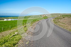 Empty country road in Ic eland under blue sky in summer