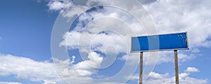 Empty country road sign, a pointer on a background of blue cloudy sky panorama