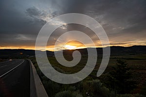 An empty countryside highway dimly lit at dusk.