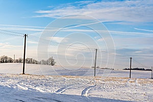 Empty Countryside Landscape in Sunny Winter Day with Snow Covering the Ground with Power Lines in Frame, Abstract Background