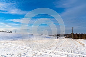 Empty Countryside Landscape in Sunny Winter Day with Snow Covering the Ground with Power Lines in Frame, Abstract Background with