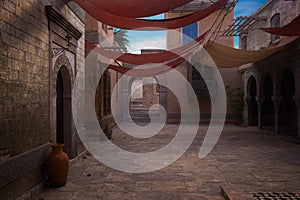 Empty courtyard in an old medieval Moroccan town with an archway leading to steps on the far side. 3D illustration