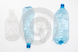 Empty crushed plastic bottles on light background