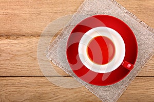 Empty cup of black tea in red cup on wooden table