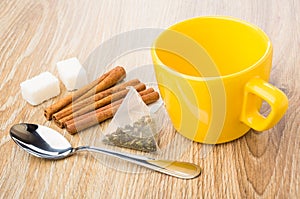 Empty cup, cinnamon sticks, teaspoon, tea bag, lumpy sugar photo