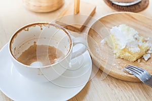Empty cup of coffee and soiled cake plate