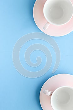 Empty cup and saucer on blue background, flatlay