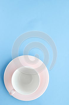 Empty cup and saucer on blue background, flatlay