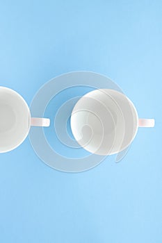 Empty cup and saucer on blue background, flatlay